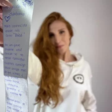 Bárbara Salgueiro segura uma mensagem de agradecimento escrita à mão por formandas.